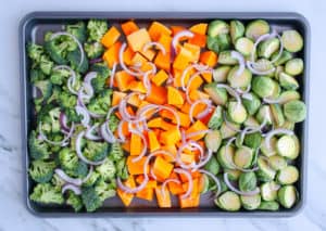 Sheet pan of broccoli, squash, brussels sprouts and red onion