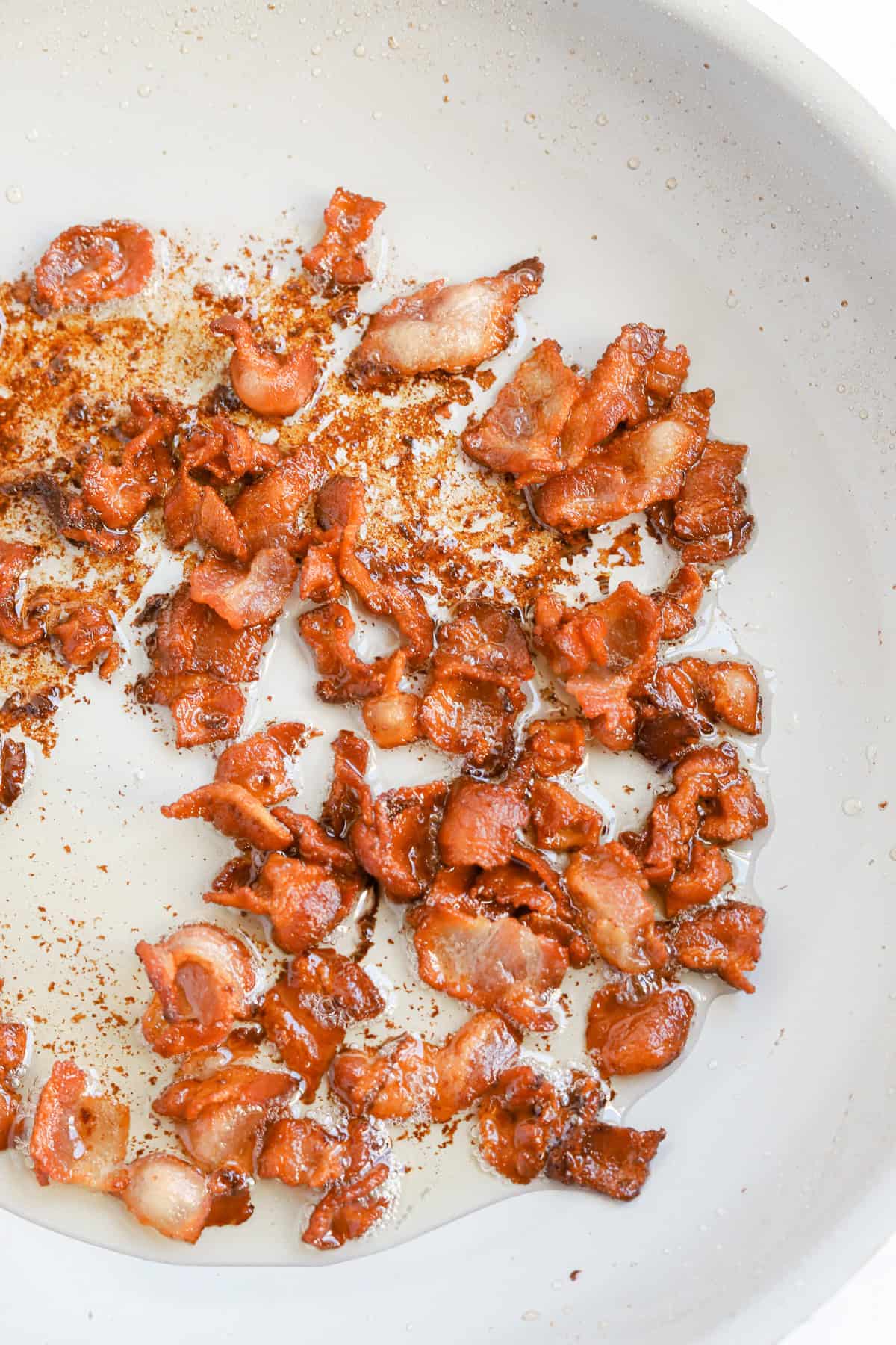 Crispy bacon pieces in a skillet.