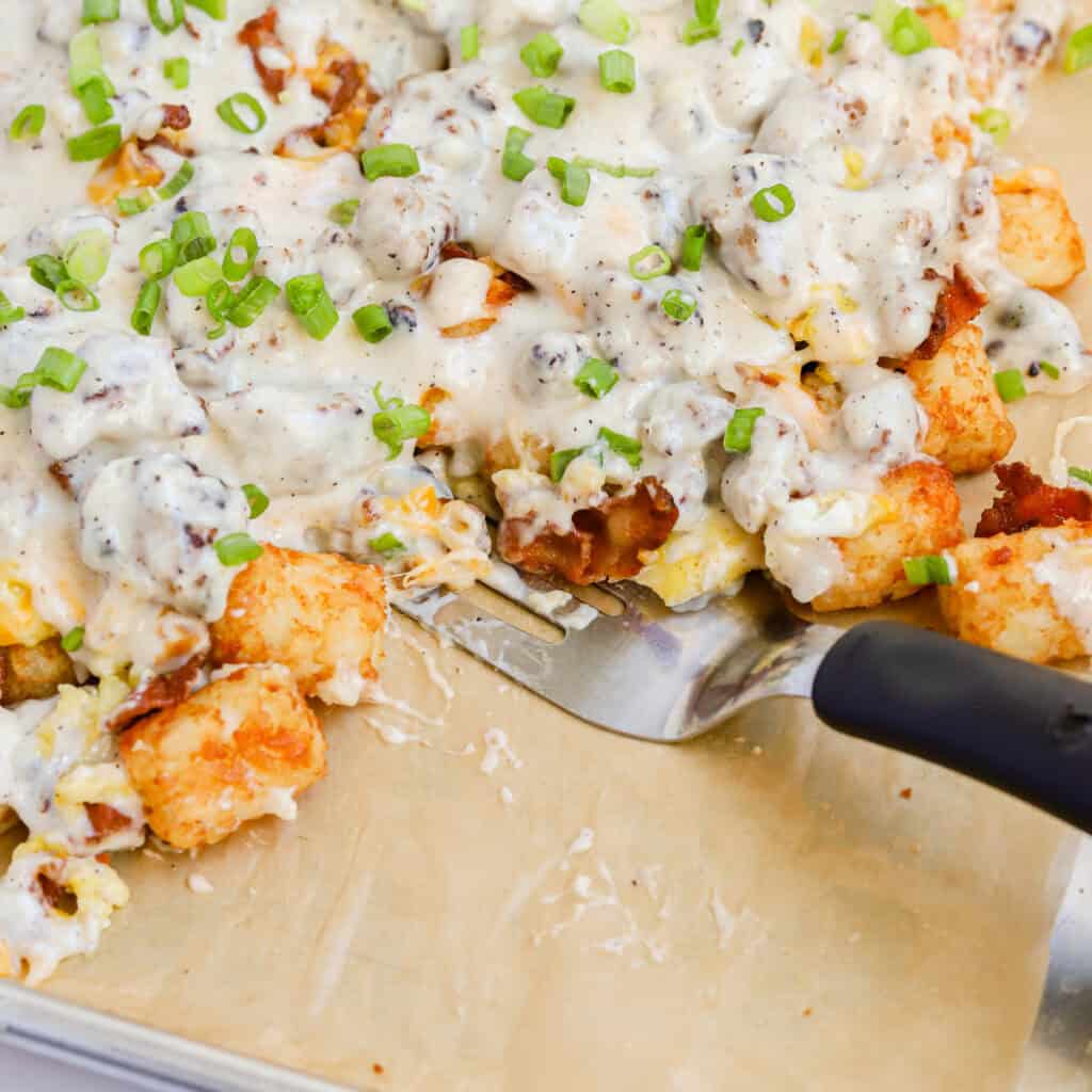 Featured closeup of black spatula on sheet pan of breakfast totchos