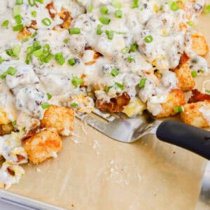 Featured closeup of black spatula on sheet pan of breakfast totchos