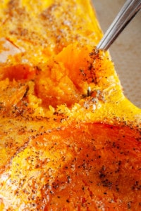 Spoon scooping out flesh of roasted butternut squash