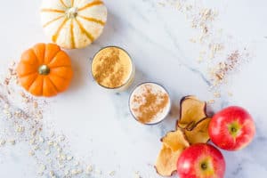 Fall Smoothies on countertop with pumpkins and apples
