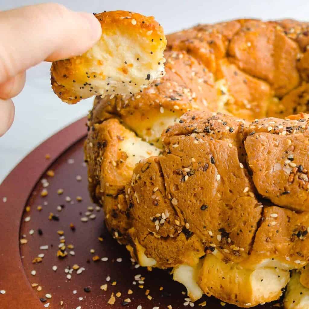 Hand pulling out a piece of bubble bread