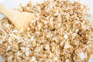 Close up of granola mixture mixed with wooden spoon