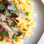 Beef stroganoff on egg noodles served on gray plate