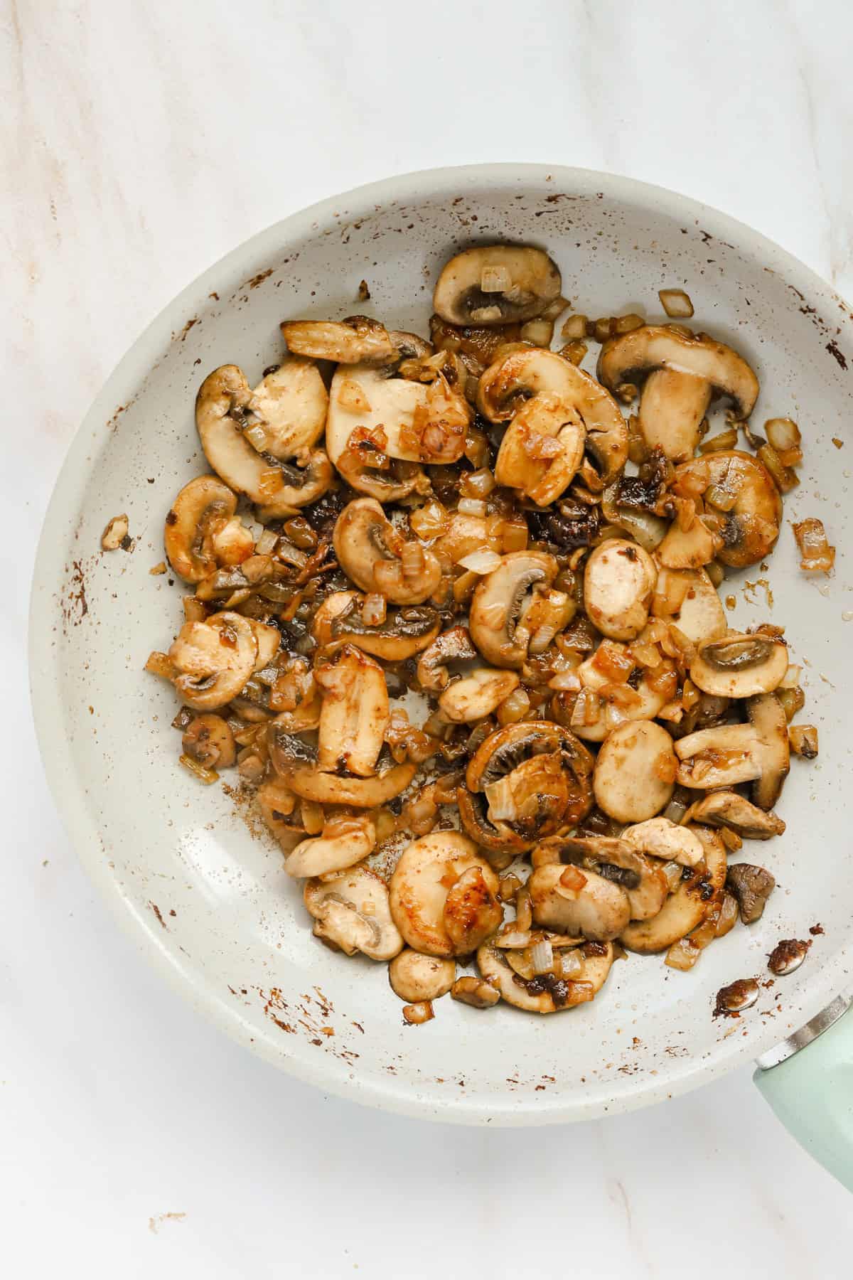 Sautéed mushrooms and onions in a skillet.