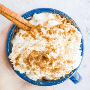 Chai Hot Chocolate with whipped cream and cinnamon in a blue mug