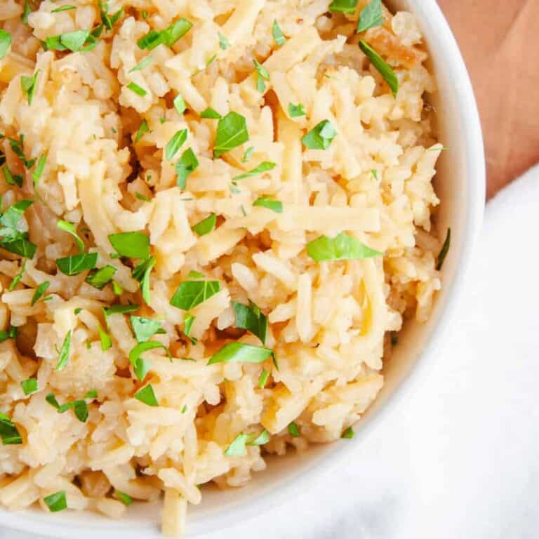White bowl of Noodle Rice Pilaf garnished with parsley