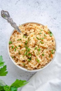 White bowl of Noodle Rice Pilaf garnished with parsley