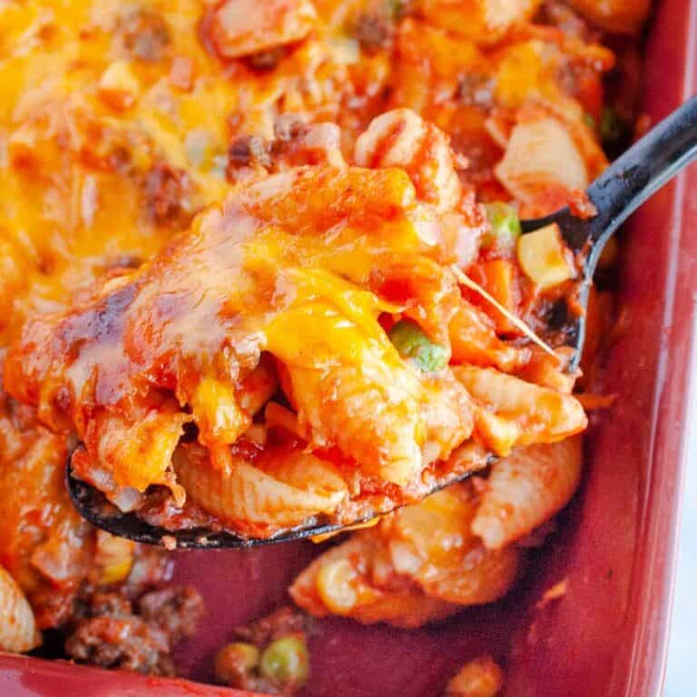 Hamburger Casserole in red baking dish with black spoon