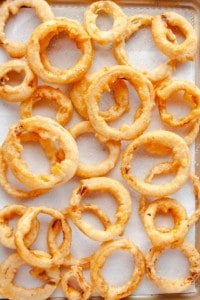 Beer Battered Onion Rings on a paper towel lined baking sheet