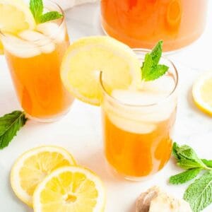 Homemade Lemonade Iced Tea in a glass garnished with mint and lemon