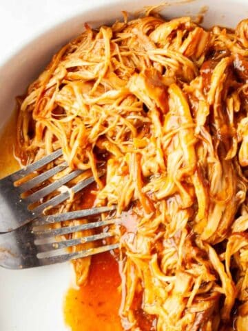 Slow Cooker BBQ Ranch Chicken in a white dish with two forks