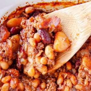 Wooden spoon scooping out Calico Baked Beans