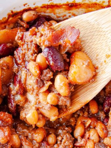 Wooden spoon scooping out Calico Baked Beans