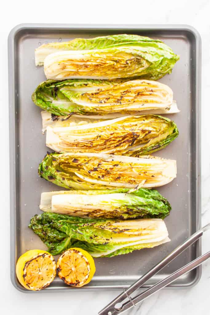 Grilled romaine hearts and lemon on a sheet pan