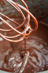Wire whisk drizzling into a pan of Homemade Hot Fudge Sauce