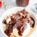 Vanilla ice cream in a white bowl topped with Homemade Hot Fudge Sauce