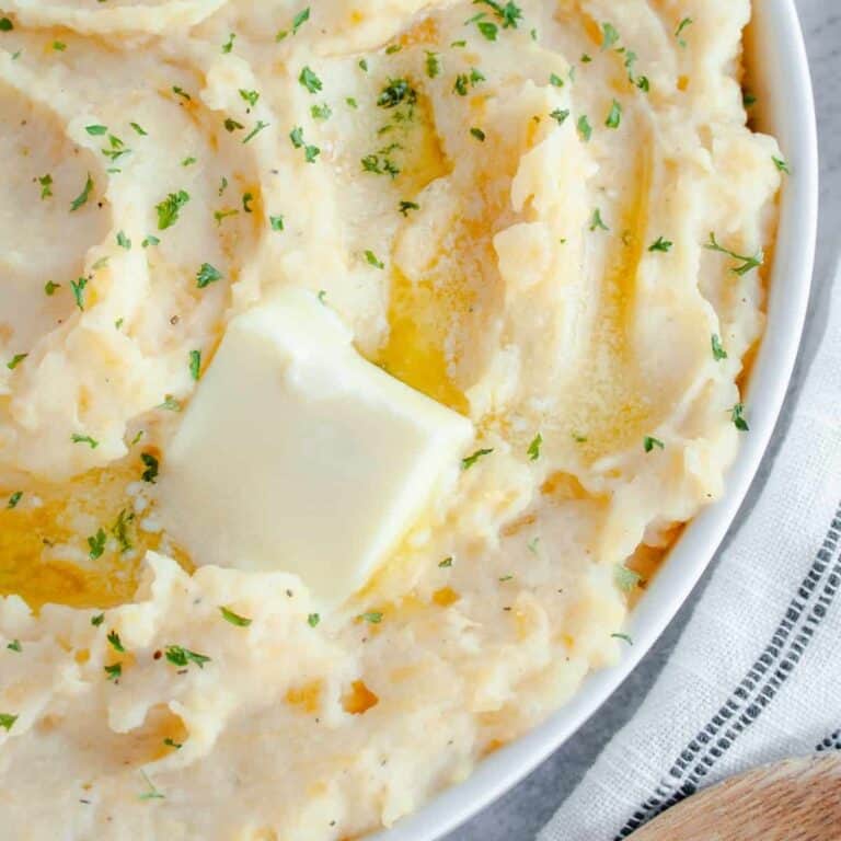 Mashed Rutabaga and Potato in a white serving dish with pat of butter on top