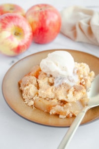 Gold plate of Cake Mix Apple Cobbler topped with vanilla ice cream