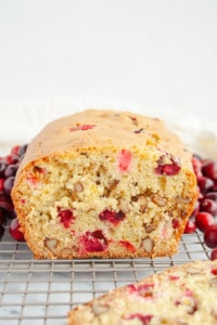 Side view of a loaf of Cranberry Walnut Bread on a wire rack