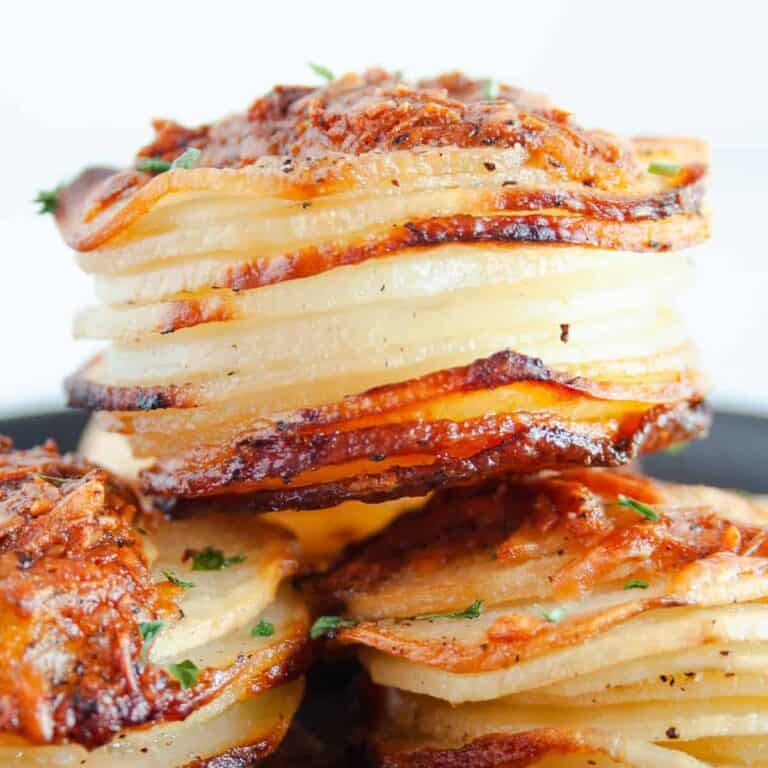 Parmesan Potato Stacks stacked on a black plate