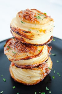 Stack of three Parmesan Potato Stacks piled on a black plate