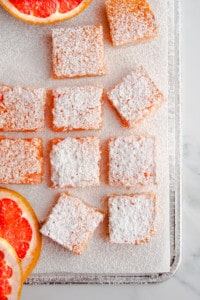 Cut grapefruit bars on parchment paper sprinkled with powdered sugar