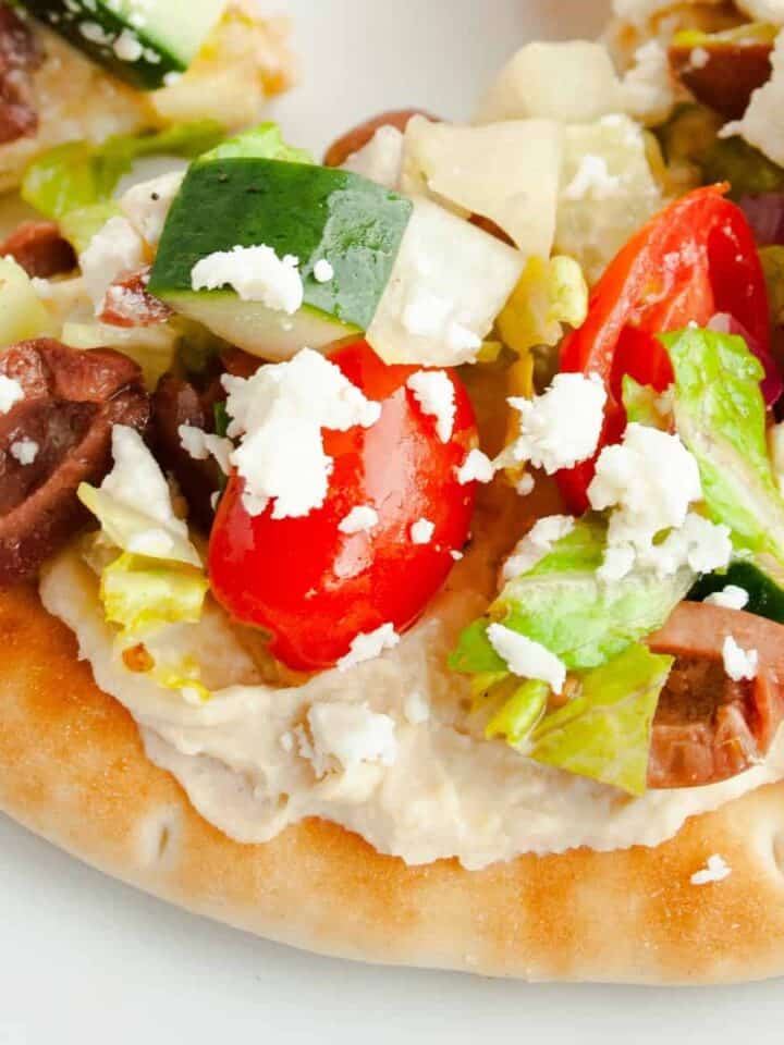Close up of a triangle piece of Greek Pita Pizza