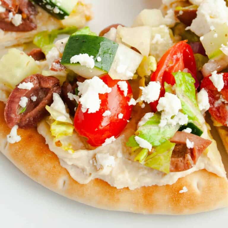 Close up of a triangle piece of Greek Pita Pizza