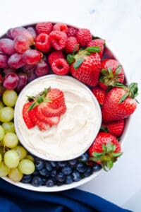 Fruit tray with Mascarpone Fruit Dip in a white dish with a cut strawberry on top