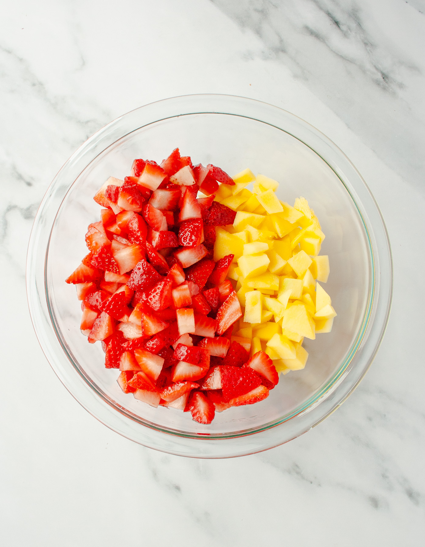 Strawberries and mango diced in a bowl.