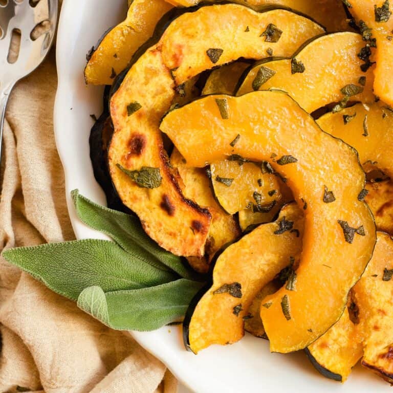 Squash on a serving platter with sage leaves