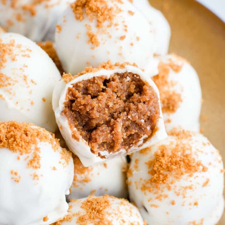 Biscoff truffles on a gold plate with a bite taken out of one