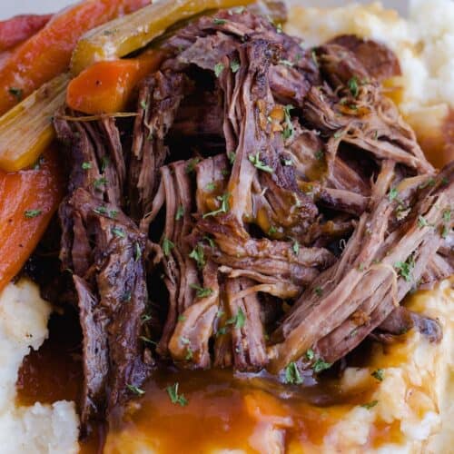 Close up of pot roast with mashed potatoes, gravy and vegetables