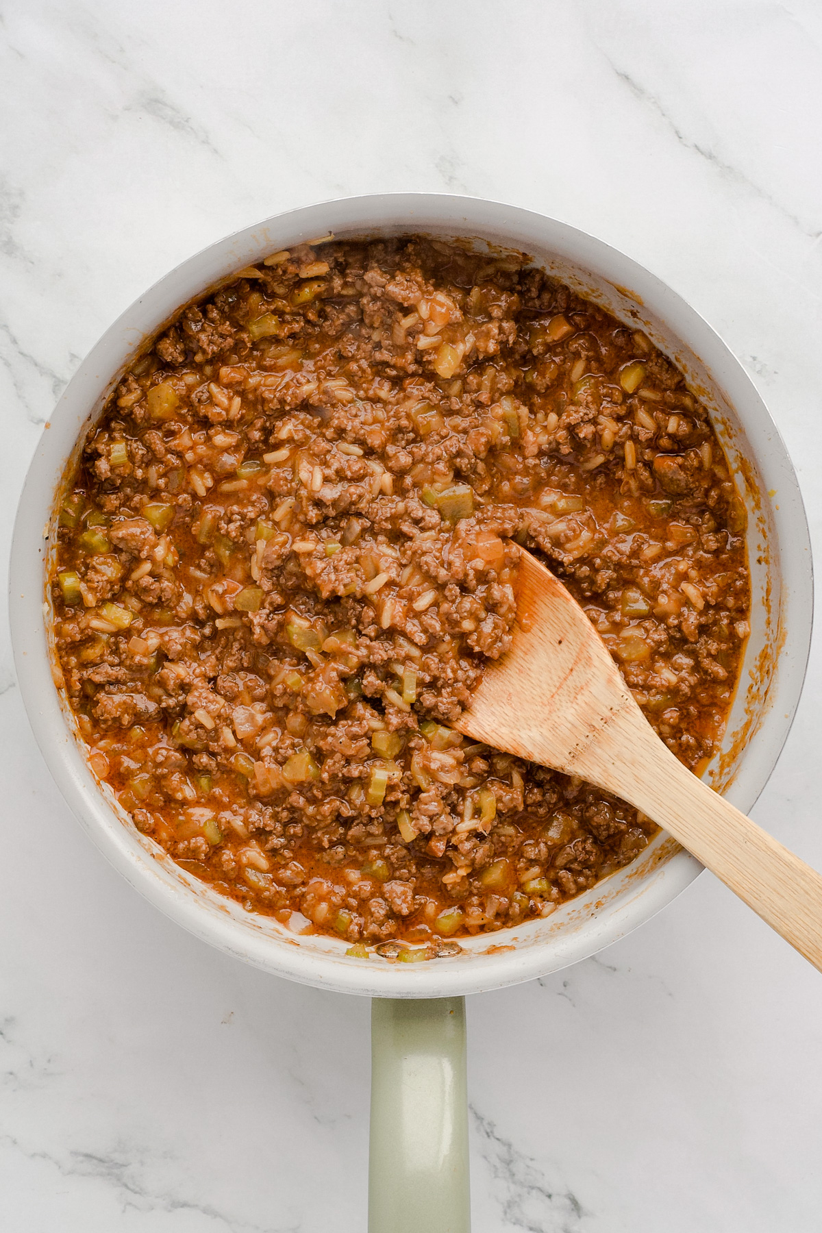 Sloppy Joe mixture in skillet with wooden spoon