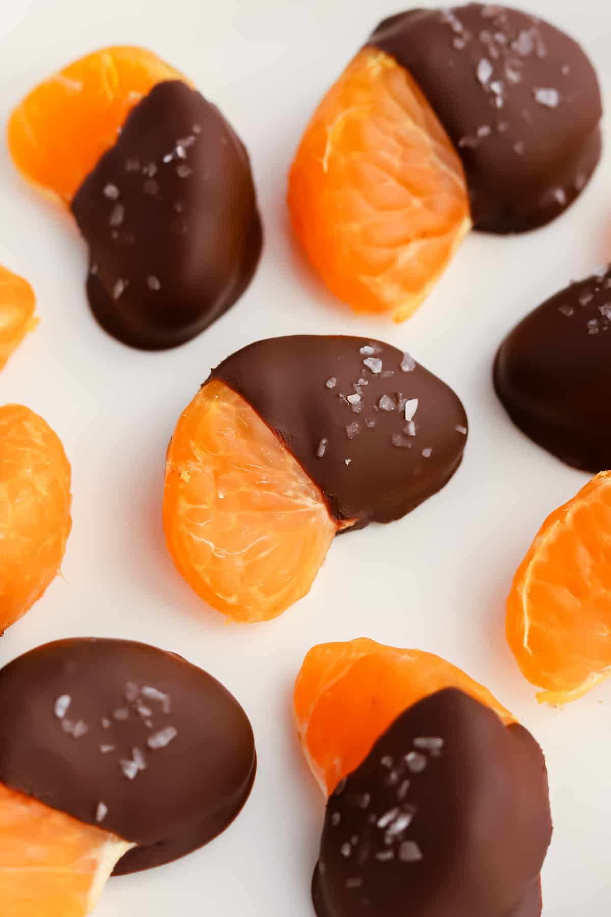 Dipped orange segments on white plate
