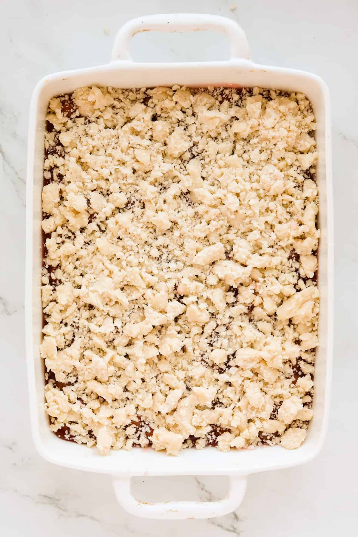 Cobbler topping covering the cherry pie filling and ready for the oven.