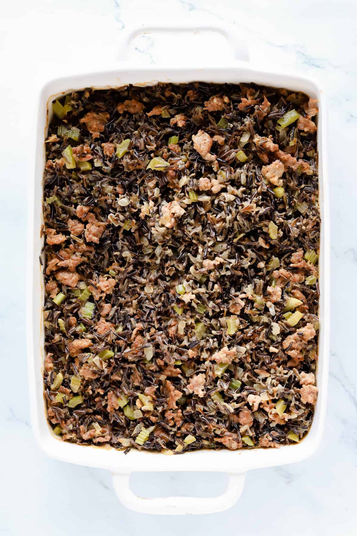 Baked wild rice hot dish in a white baking dish.
