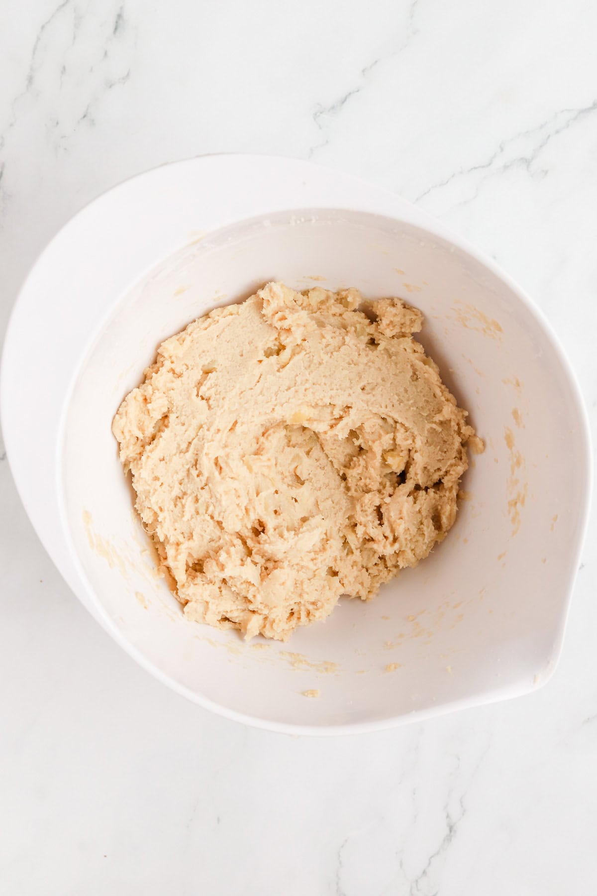 Pineapple cookie dough in a white mixing bowl.
