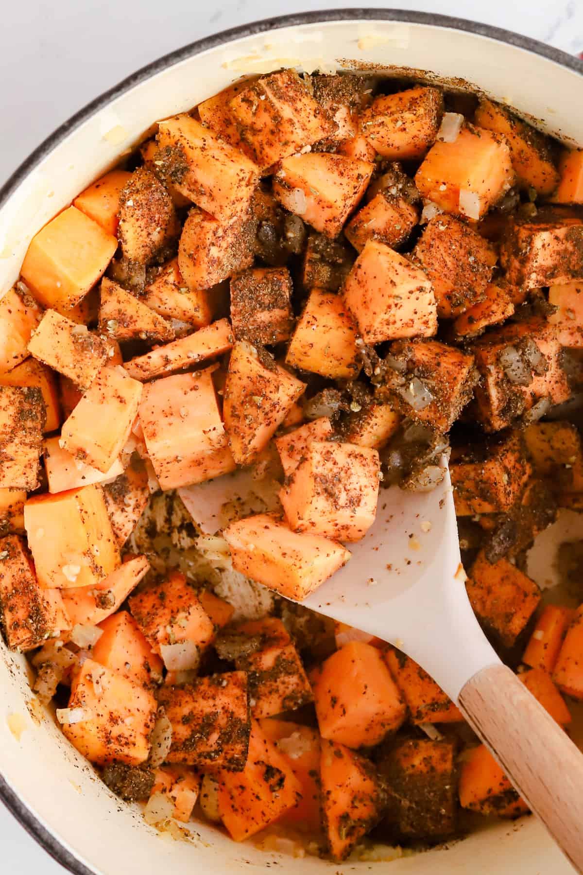 Seasoned diced sweet potatoes and onion sautéed in Dutch oven.