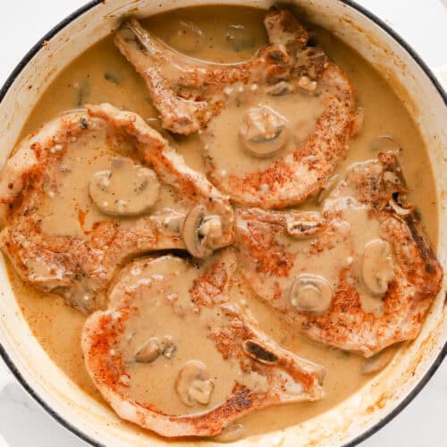 Square photo of pork chops in mushroom gravy.