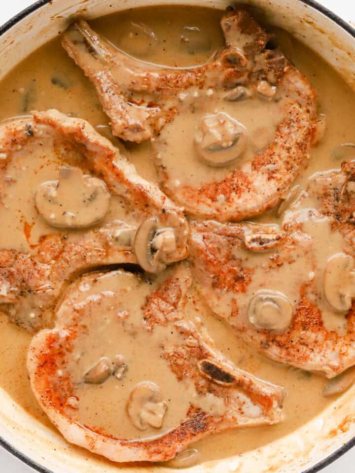Square photo of pork chops in mushroom gravy.
