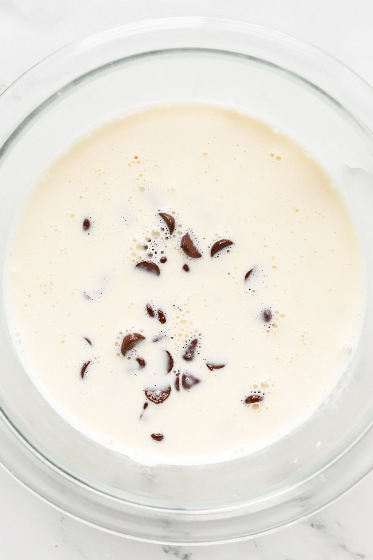 hot cream and semi-sweet chocolate chips in a bowl to create ganache.