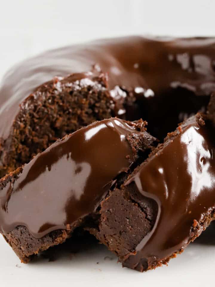 Two slices of chocolate mayo cake shingled alongside the rest of the bundt cake.