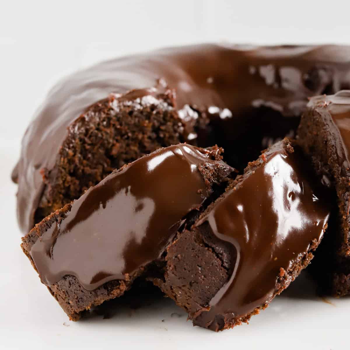 Two slices of chocolate mayo cake shingled alongside the rest of the bundt cake.
