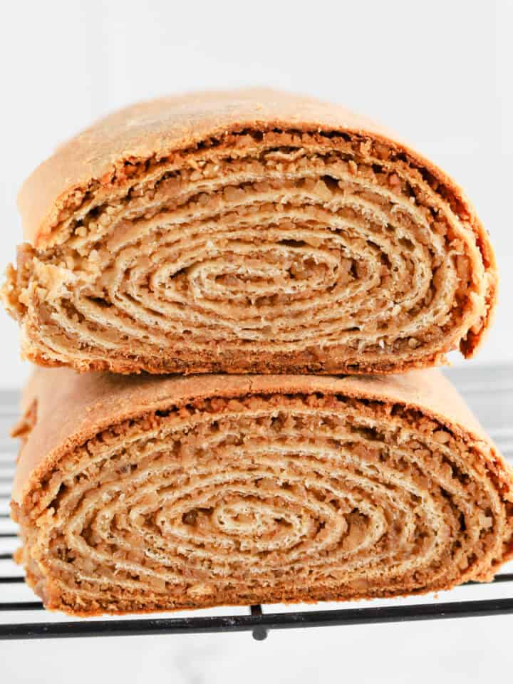 Potica loaves stacked on top of each other on wire rack revealing spiral center.