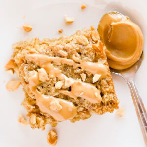 Close up of a square of peanut butter baked oatmeal with more peanut butter drizzled on top.