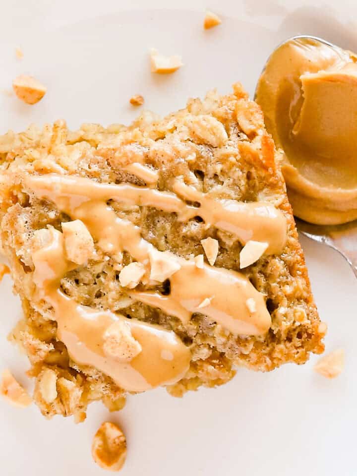 Close up of a square of peanut butter baked oatmeal with more peanut butter drizzled on top.