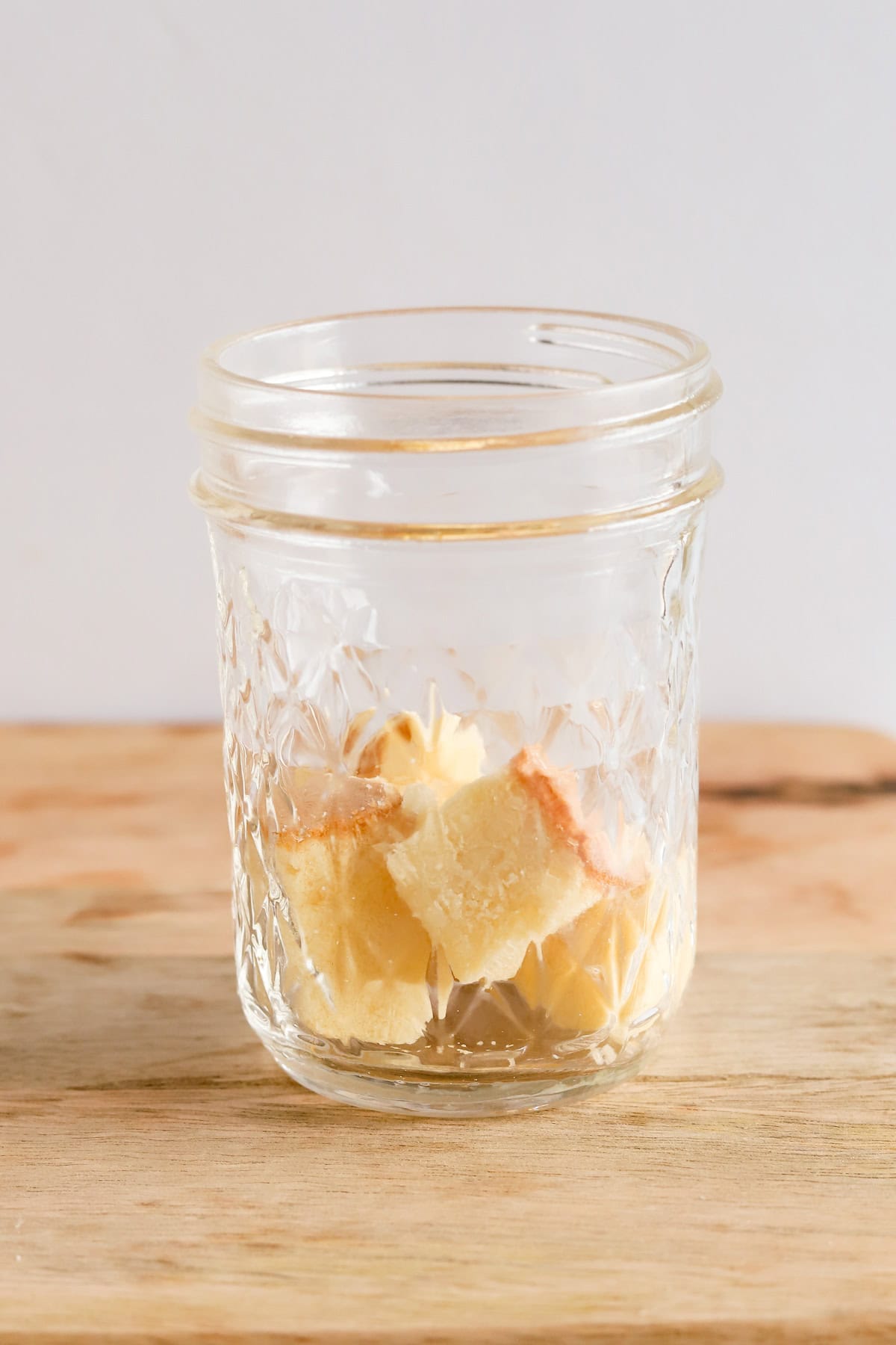 Cubes of pound cake in the bottom of a mason jar.